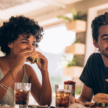 Friends smiling while eating lunch at restaurant