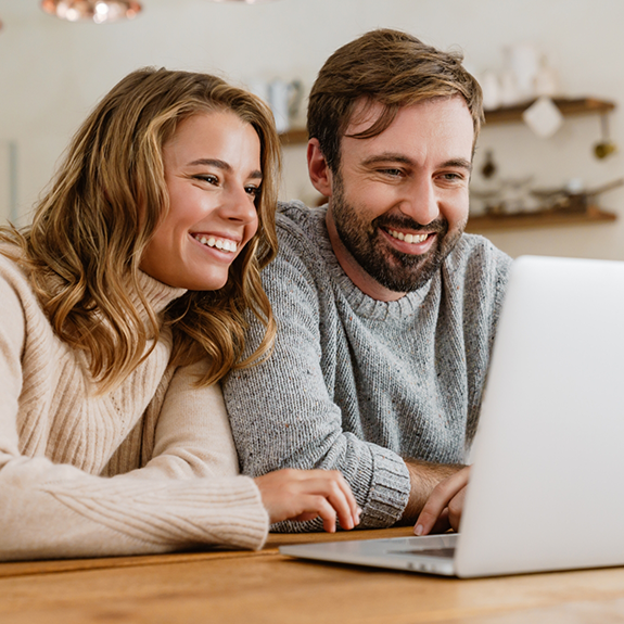 Smiling woman in striped shirt working on laptop