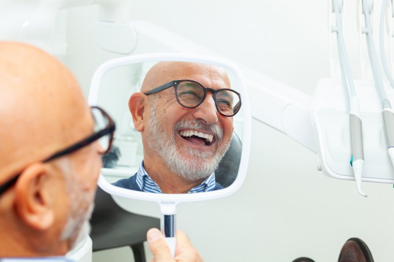 A senior man admiring the results of his cosmetic dentistry
